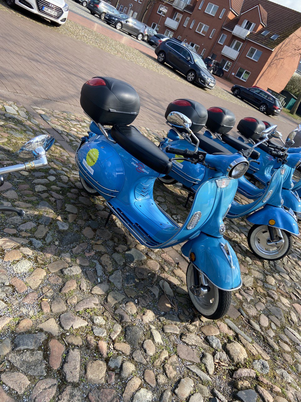 Mehrere, blaue, Elektro Roller mit ProEngeno Werbung in einer Reihe.